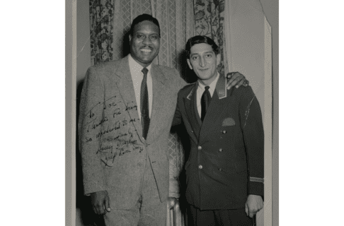 Signed black and white photograph with slightly weathered edges of Joe Maruca in his porter’s uniform posing with Harry Douglas.