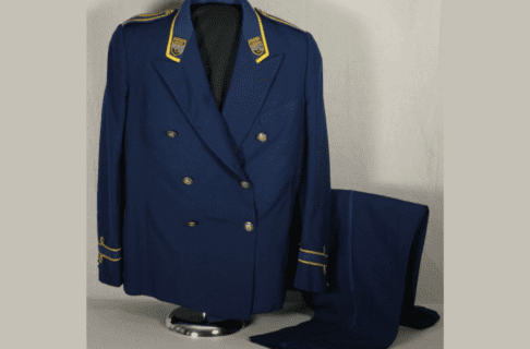 A vintage blue Porter’s uniform with the jacket on a clothing form and the trousers laid beside.