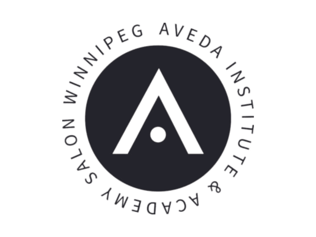 Aveda Institute logo. A black circle with a stylized A in the centre. Around the circle text reads, “Winnipeg Aveda Institute & Academy Salon”. 