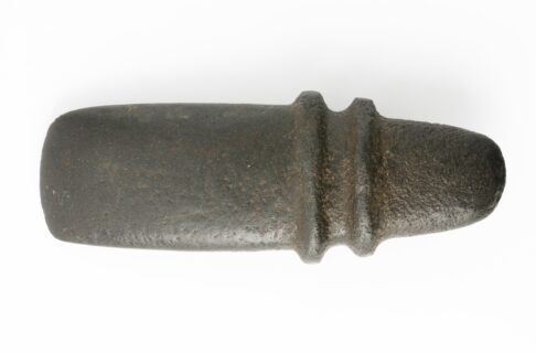 A polished axe head carved from dark stone, with two raised ridges near the handle end.
