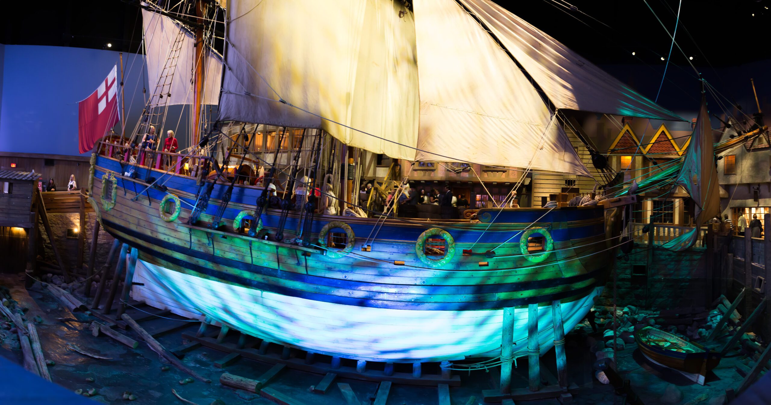A fish-eye lens view of the Nonsuch, a large wooden ship, lit in blues and whites from below.