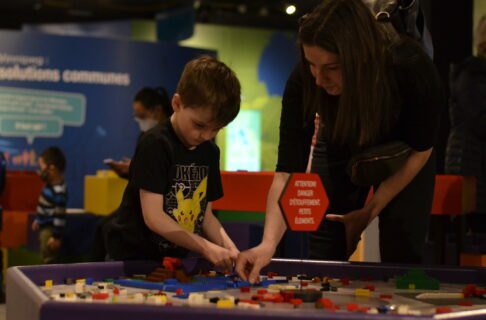 A child and adult working together to build something at a Lego table in the Science Gallery.