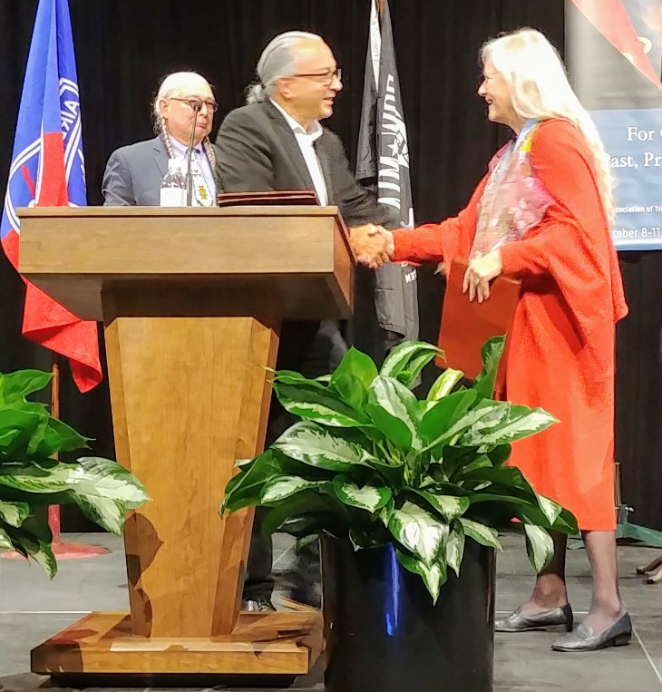 Dr. Matthew shaking the hand of an individual behind a podium.