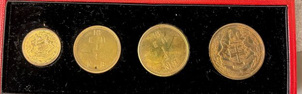 Four brass trade tokens with HBC coat of arms in a black velvet case.