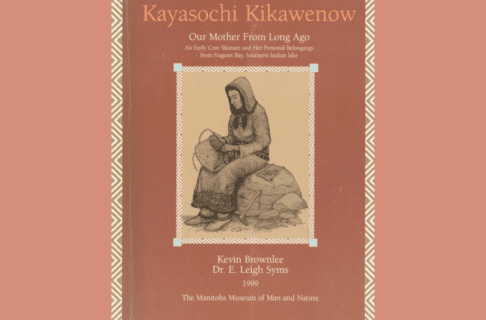 Book cover featuring an illustration of a Cree woman sitting on a rock, weaving a basket. At the top the title reads, “ Kayaskochi Kikawenow: Our Mother from Long Ago / An Early Cree Woman and Her Personal Belongings from Nagami Bay, Southern Indian lake”. At the bottom reads, “Kevin Brownlee / Dr. E. Leigh Syms / 1999 / The Manitoba Museum of Man and Nature”.