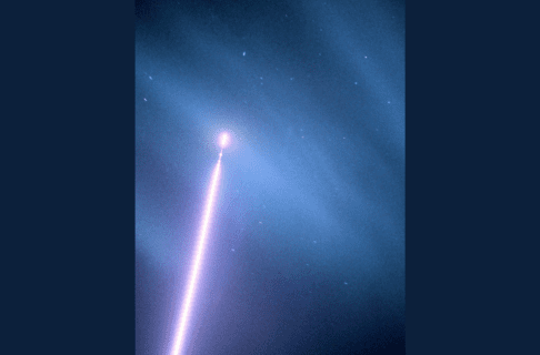 A rocket streaming up into the night sky with a bright tail behind it. In the dark blue night sky, light lines of aurora and stars are visible.