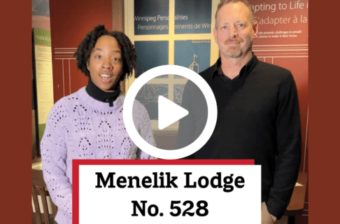 A video screenshot of two individuals standing side by side speaking to the camera with a play button over top. Overlaid text reads, "Menelik Ledge No. 528".