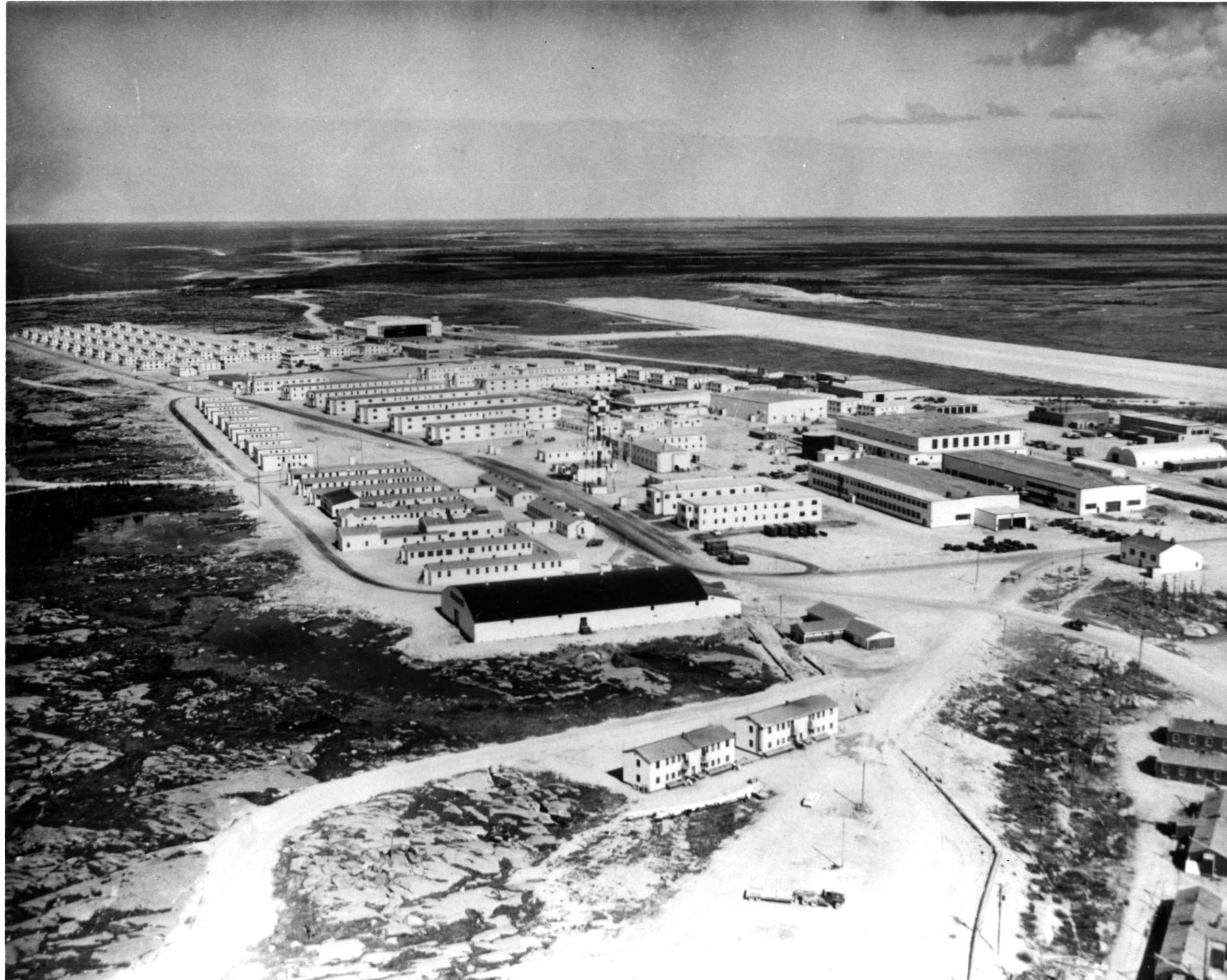 Black and white aerial photograph looking down on rows of barracks.