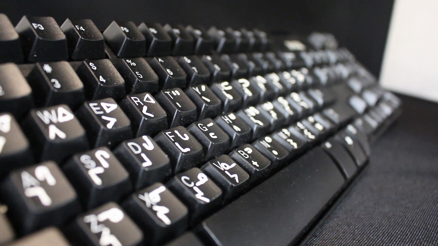 A computer keyboard with English, Ininiwag, and Anishininiwag syllabics on the keys.