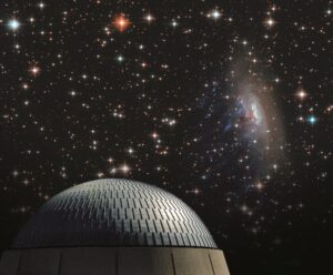 The exterior of the Planetarium dome in front of a starry night sky.