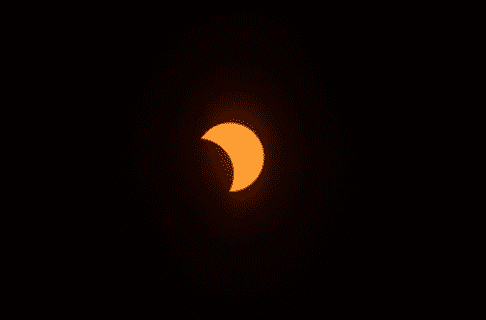 A crescent of the sun mid-eclipse as the moon passes between it and Earth.