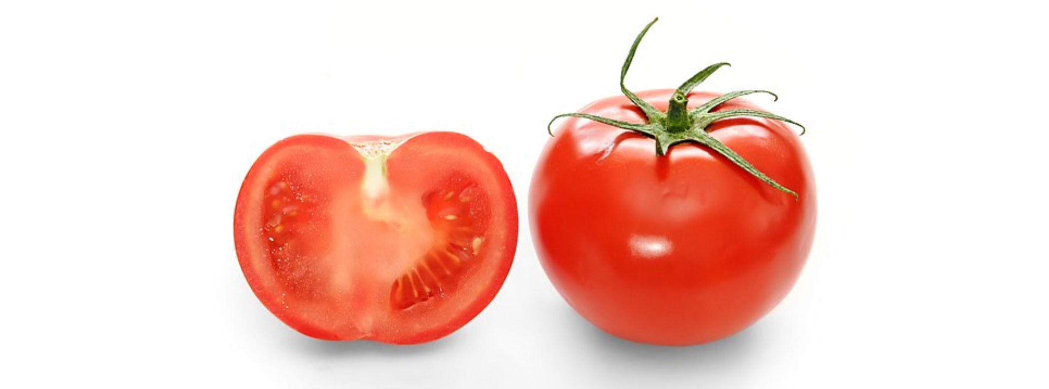 Two red tomatoes on a white background. The tomato on the left is cut open, showing the inside. The tomato on the right is whole.