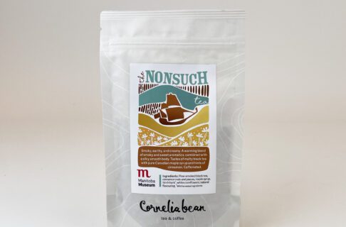 A package of loose leaf tea with a colourful illustrated label identifying it as the Nonsuch tea, and featuring the Nonsuch ship over a yellow layer with white accent flowers.