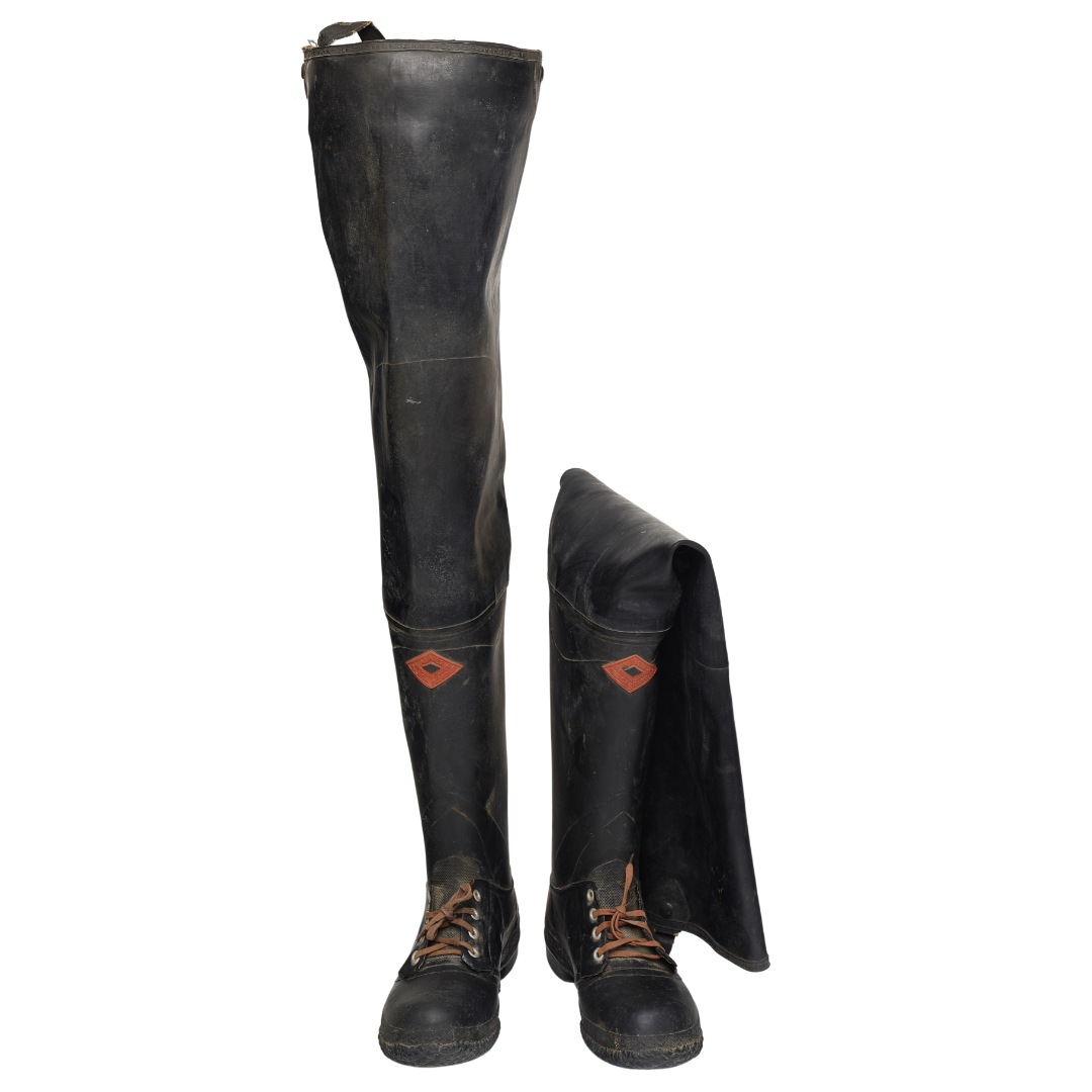 A pair of tall black hip wader boots. The boot on the right is folded over, while the left boot stands at full height.