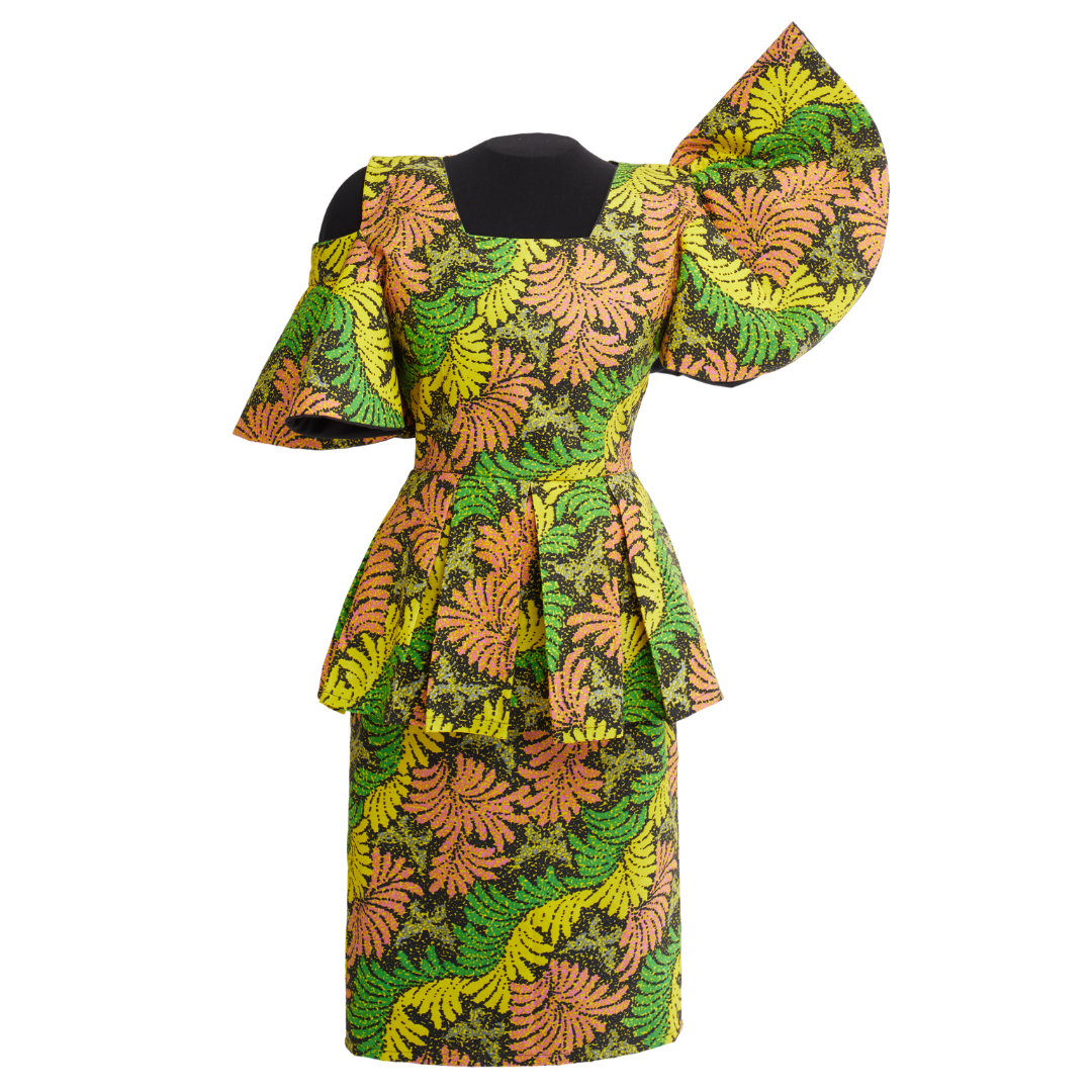 A dress with a flared waistline and short flared sleeves. The fabric has leaf a pattern in green, yellow, and orange-red.