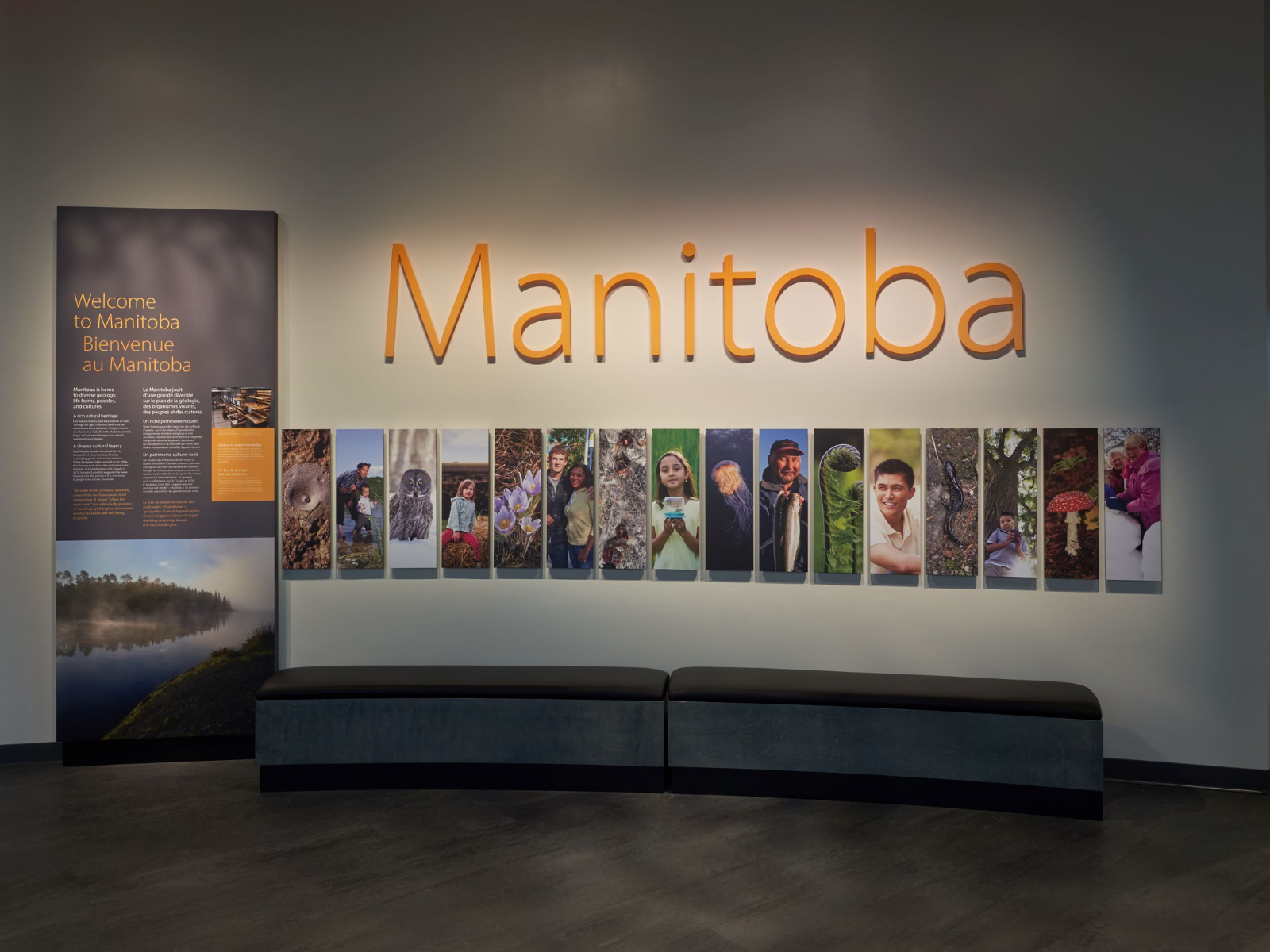 Two benches in front of a wall featuring a series of photographs of Manitoba people and nature. Above the photographs is written "Manitoba", and to the left is a text panel titled, "Welcome to Manitoba".