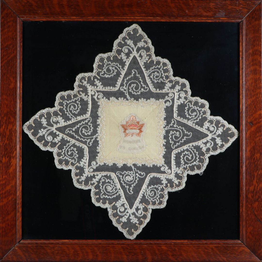 A framed silk handkerchief with lace detailing.