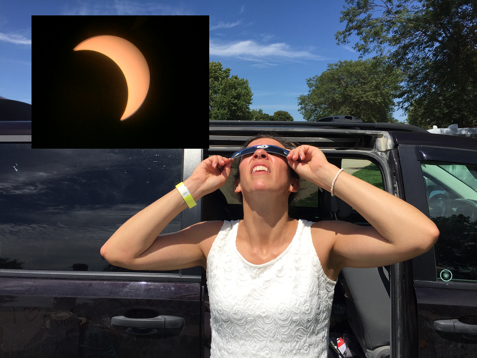 A woman looks at the Sun using safe eclipse glasses.