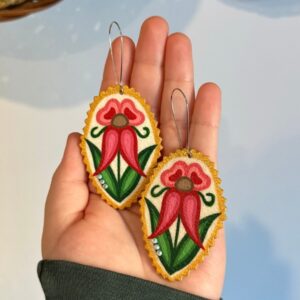 A pair of rawhide earrings featuring a pink flower.