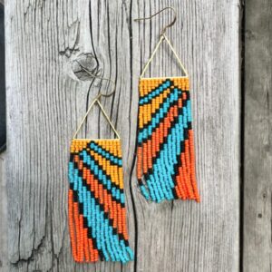 A pair of beaded dangling earrings in a sunbeam design featuring yellow, blue, orange, and black beads.
