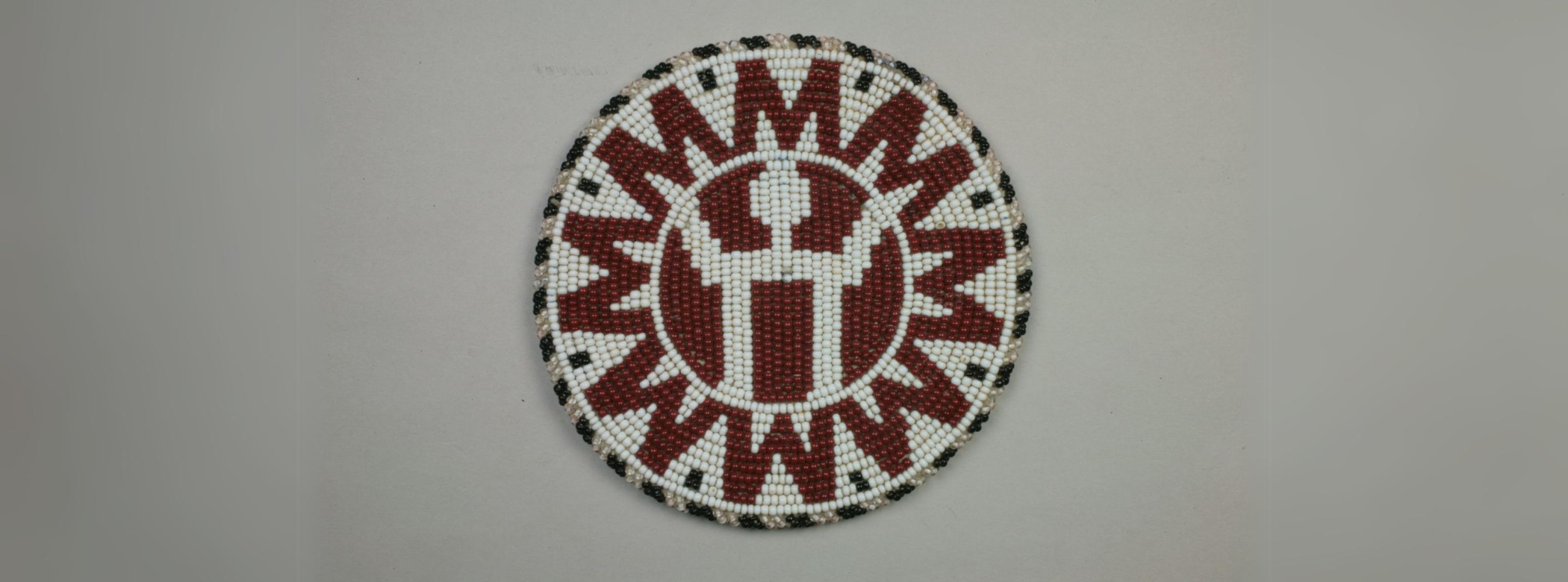 A circular beaded coaster with red 