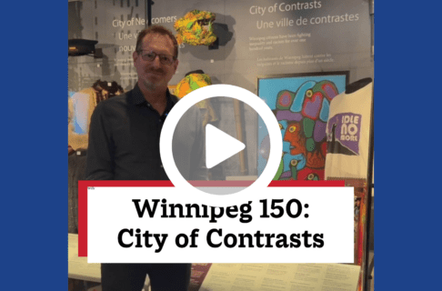 A screenshot of a video, an individual standing in front of a display case containing a number of artifacts including a brightly coloured painting. There's a play button over the screenshot and overlaid text reads, "Winnipeg150: City of Contrasts".