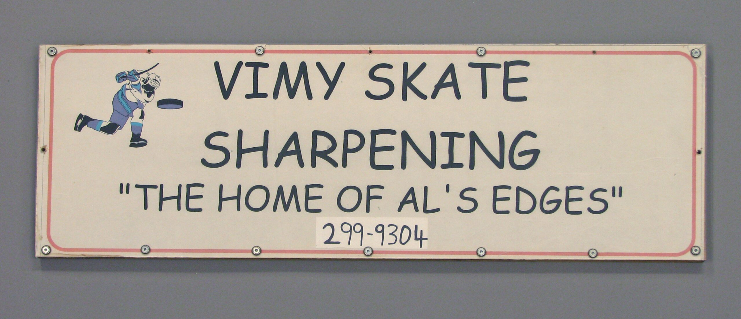 A sign with a small picture of a hockey player in the upper left corner. Text reads, 