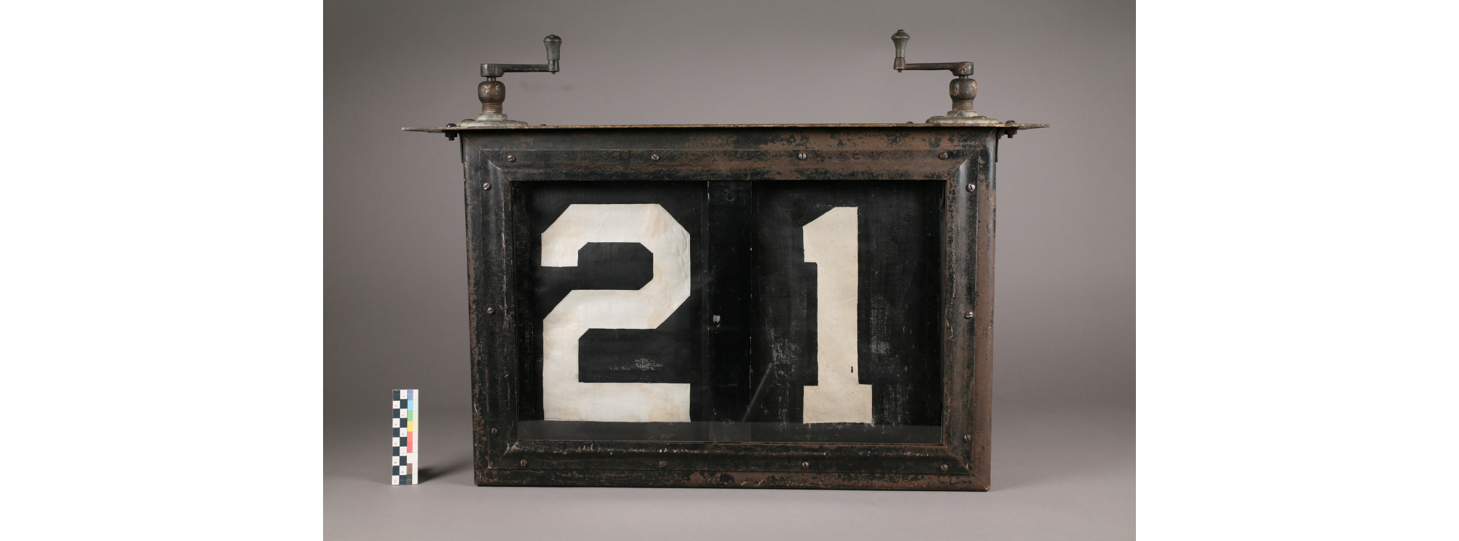 The rectangular sign with cranks on either end of the top, with two strips of fabric showing the numbers 2 and 1. The sign is much clearer than in previous images above.