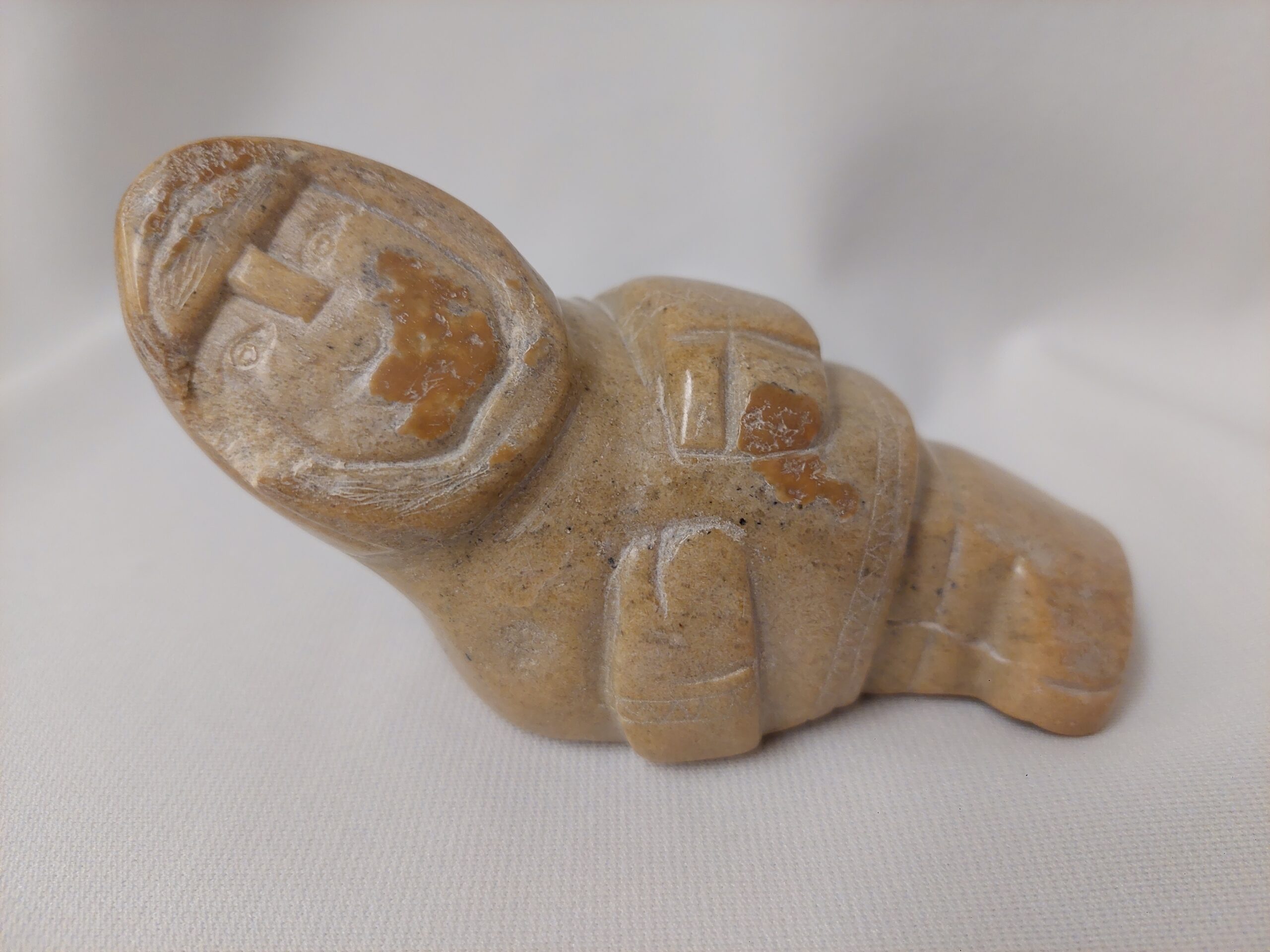 A carved soapstone figurine shaped like a person.