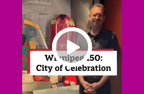 A screenshot of a video, an individual standing in front of a display case containing a number of artifacts including purple jingle dress. There's a play button over the screenshot and overlaid text reads, "Winnipeg150: City of Celebration".