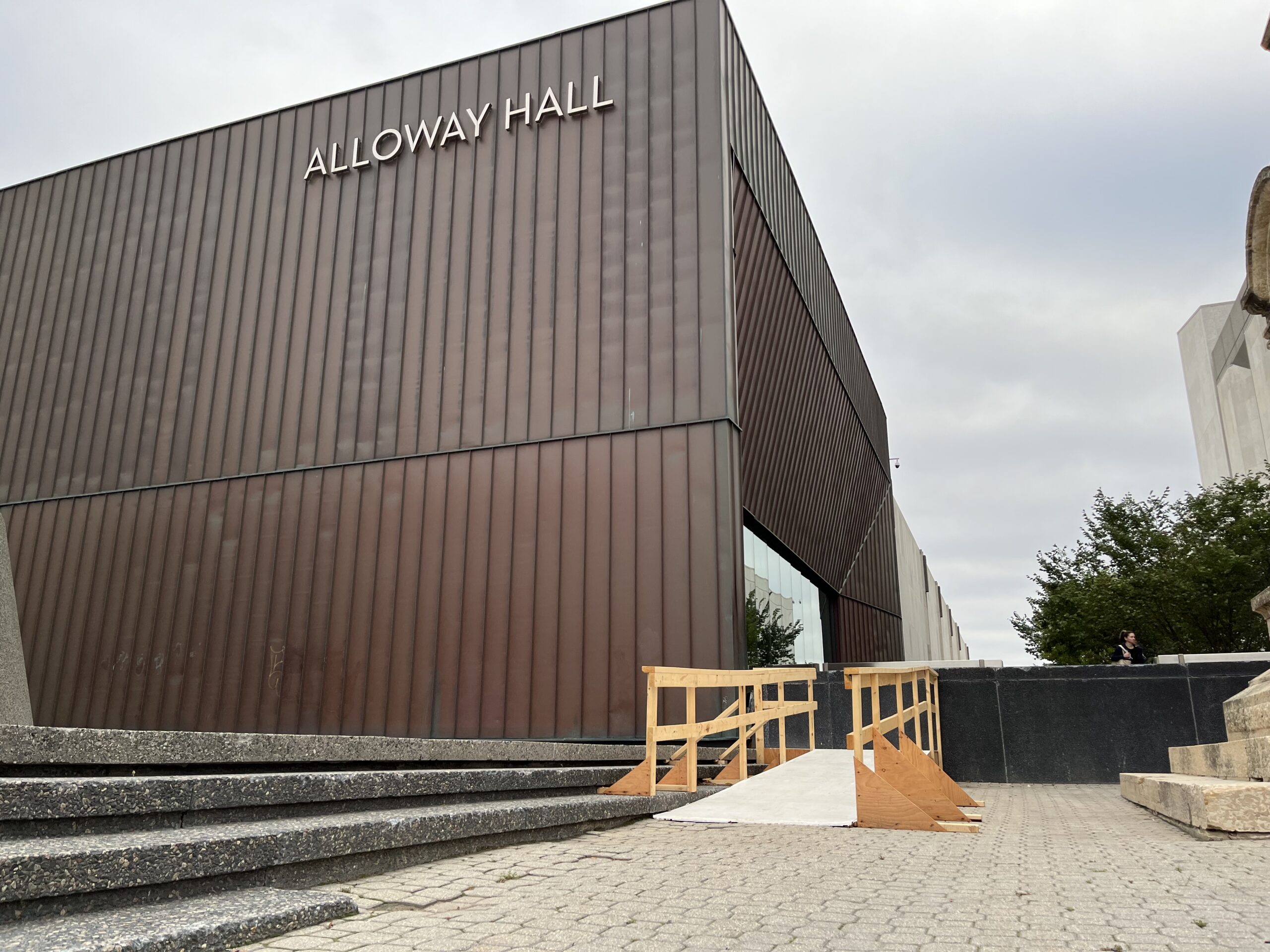 A plywood access ramp at one end of a staircase next to the Manitoba Museum's Alloway Hall.