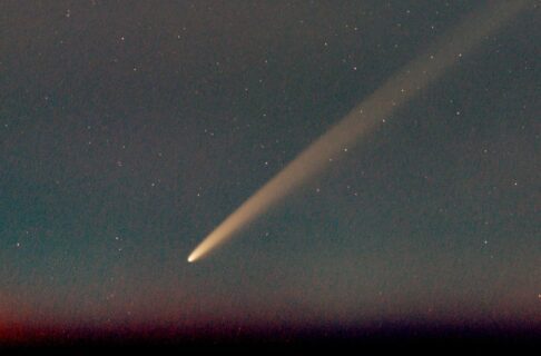 A bright comet is seen against a starry sky.