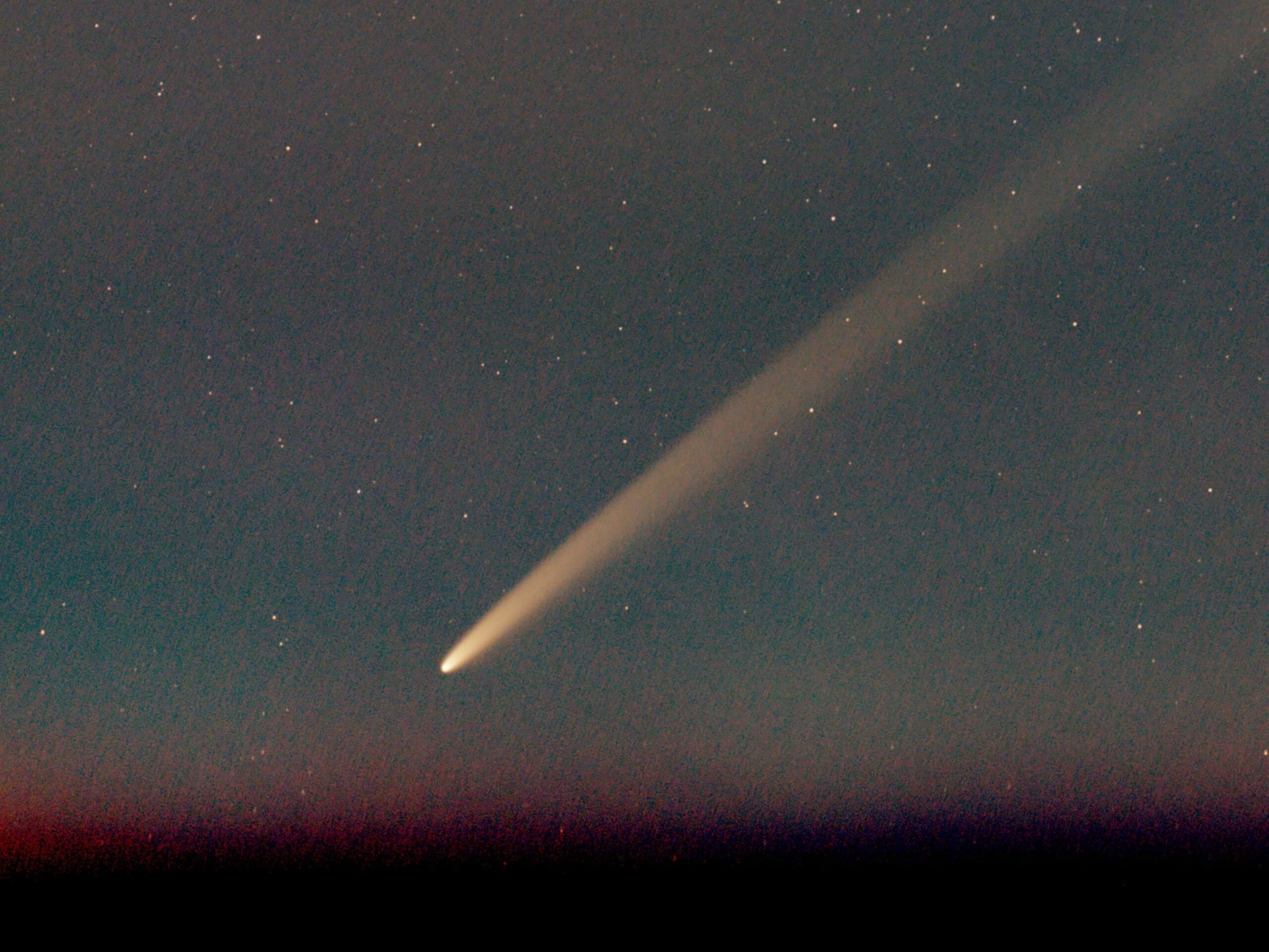 A bright comet is seen against a starry sky.