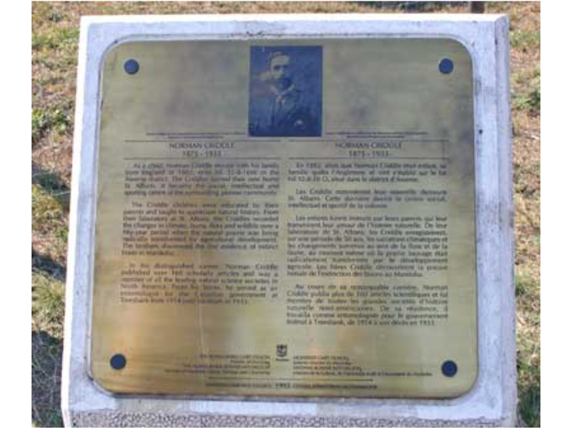 An outdoor plaque sharing some of the history of Norman Criddle in both English and French.