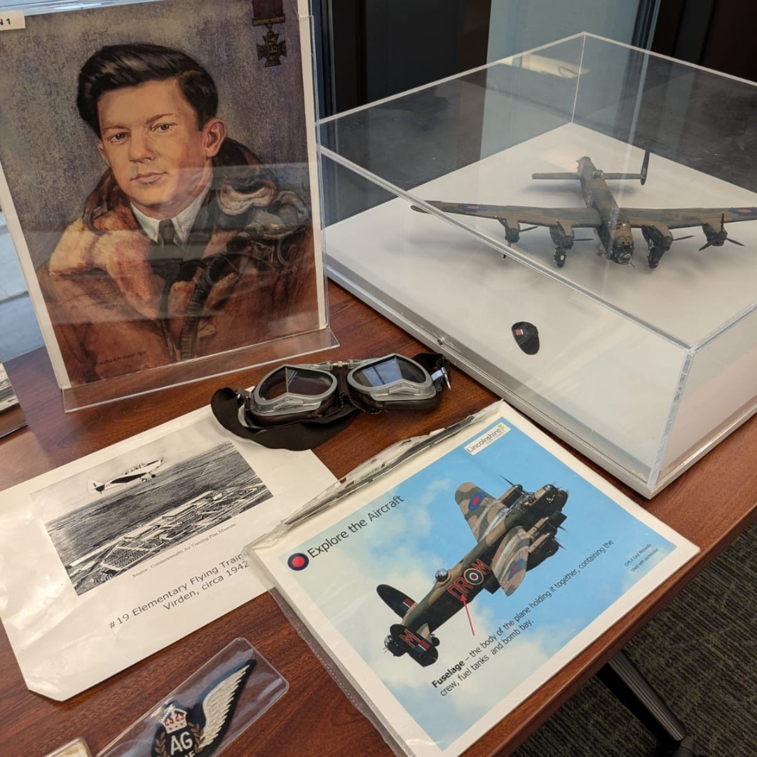 Close up look at some of the hands-on materials from the Manitobans and World War II program, including photographs, a model airplane, and artifacts.