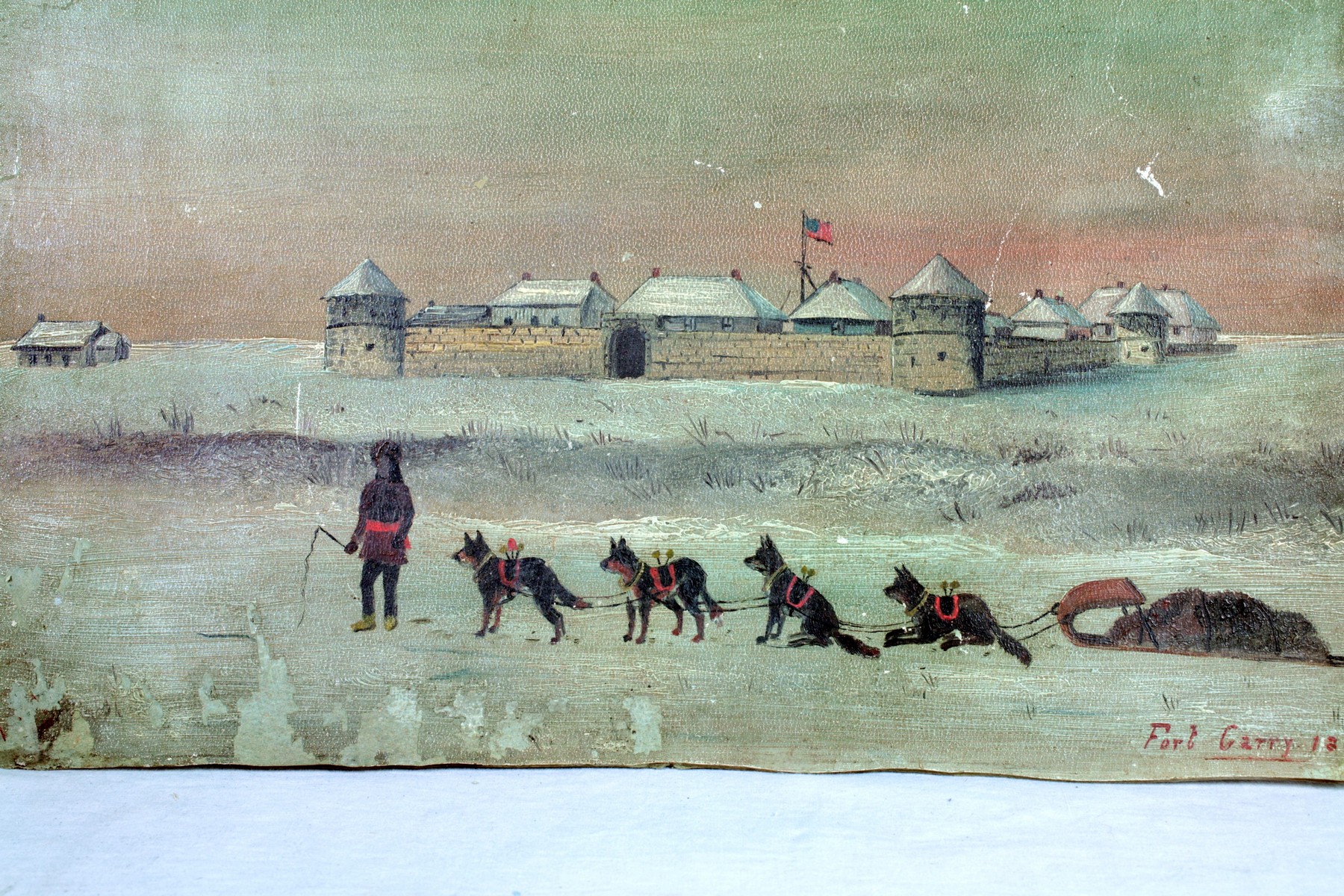 An oil painting that shows some signs of age around the edges but is clean. A winter scene where an individual stands with a dog sled team in the snow in front of a large stone fort.