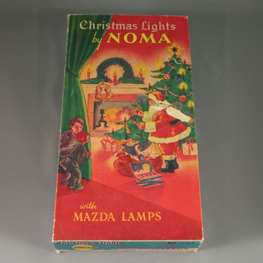 A closed vintage cardboard box of Christmas lights, portraying a two children peeking around a curtain to see Santa Claus dressing the tree with lights pulled from his sack of gifts. Text reads, "Christmas Lights by NOMA / with Mazda lamps".