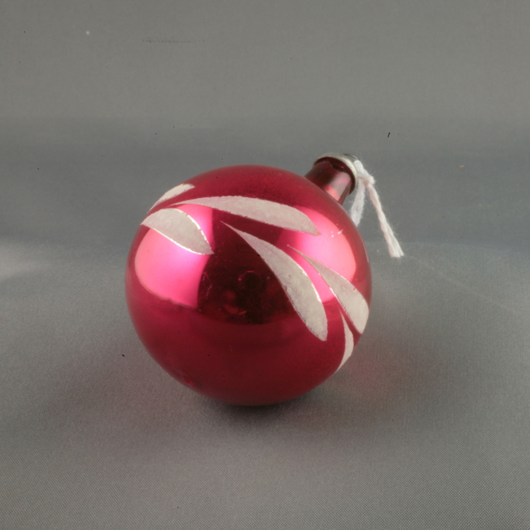 Small red bauble Christmas tree ornament with white accenting wreathing the centre.