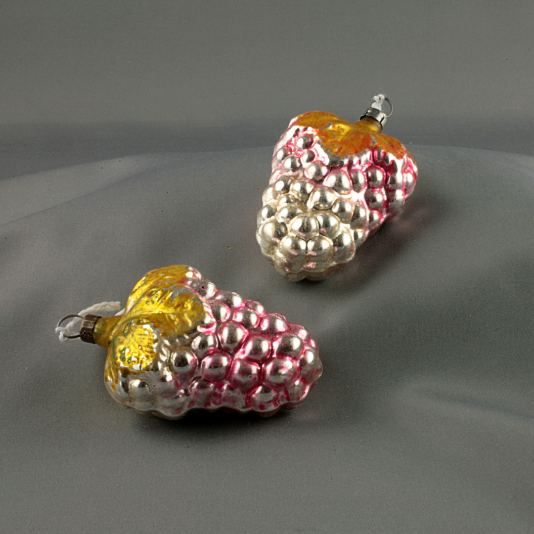 Two small red and gold raspberry Christmas tree ornaments.