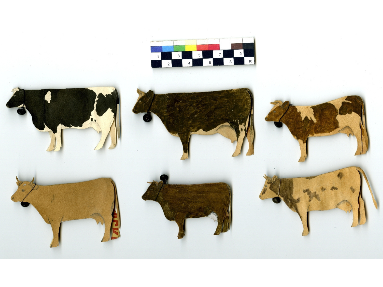 Six diligently hand-painted paper cut outs of cows.