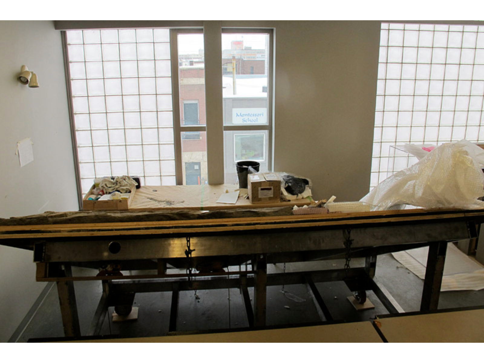 A large sturdy steel frame with wood edging seen in a workroom from above.