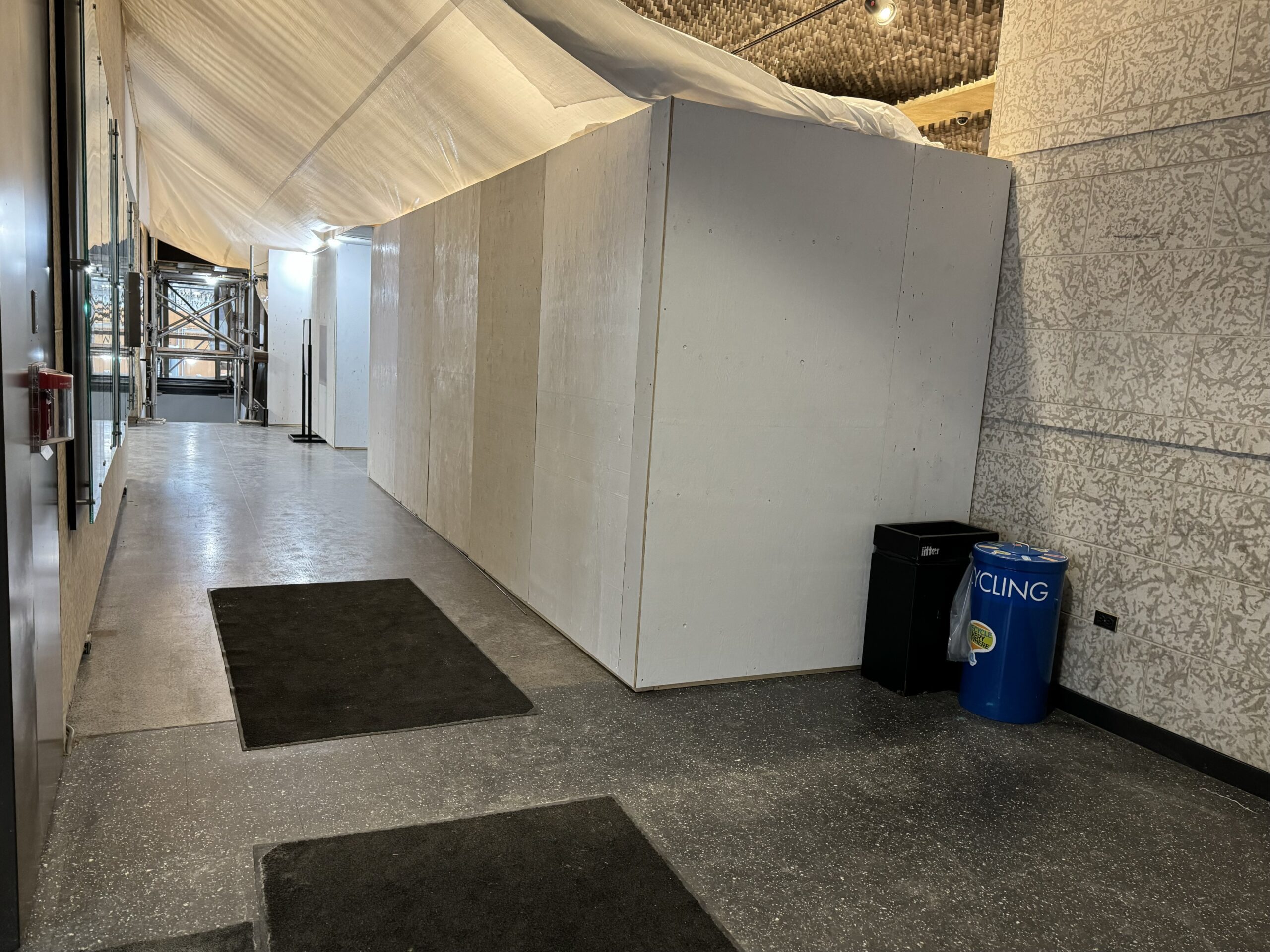 View into the Museum Foyer from the Main street entrance. Hoarding blocks off most of the Foyer, allowing for entrance towards the elevator, the stairwell, and the Museum Galleries.