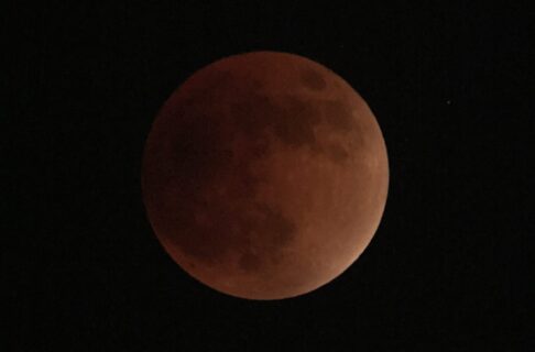 A full moon during a lunar eclipse, tinted orange.