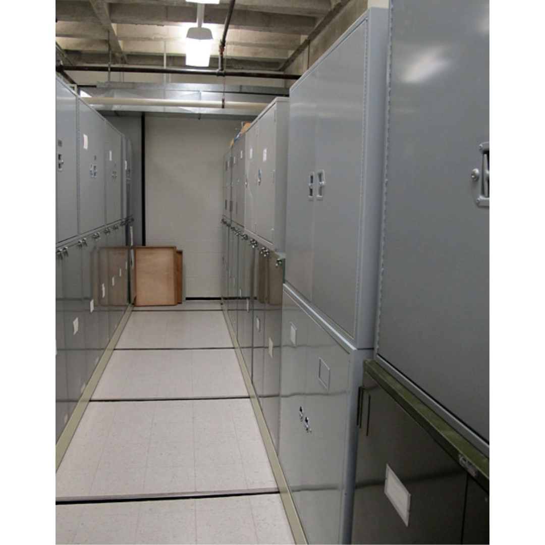 View down a storage room aisle, with metal cabinets lining either side.