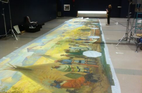 An oversized mural rolled out on the floor of a large space.