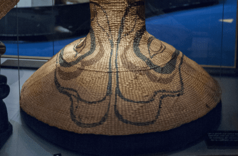 A bowl-shaped woven hat with green and red detailing around the brim.