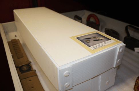 A long white box with a photograph of the contents taped onto the top.