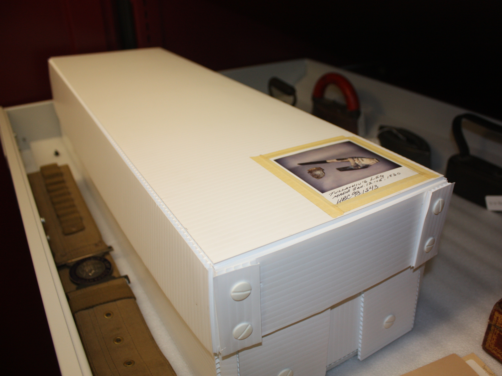 A long white box with a photograph of the contents taped onto the top.