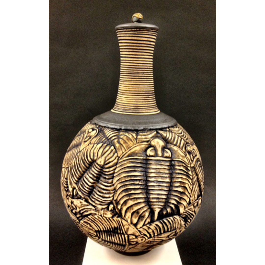 An elaborately engraved vase covered in black trilobite designs.