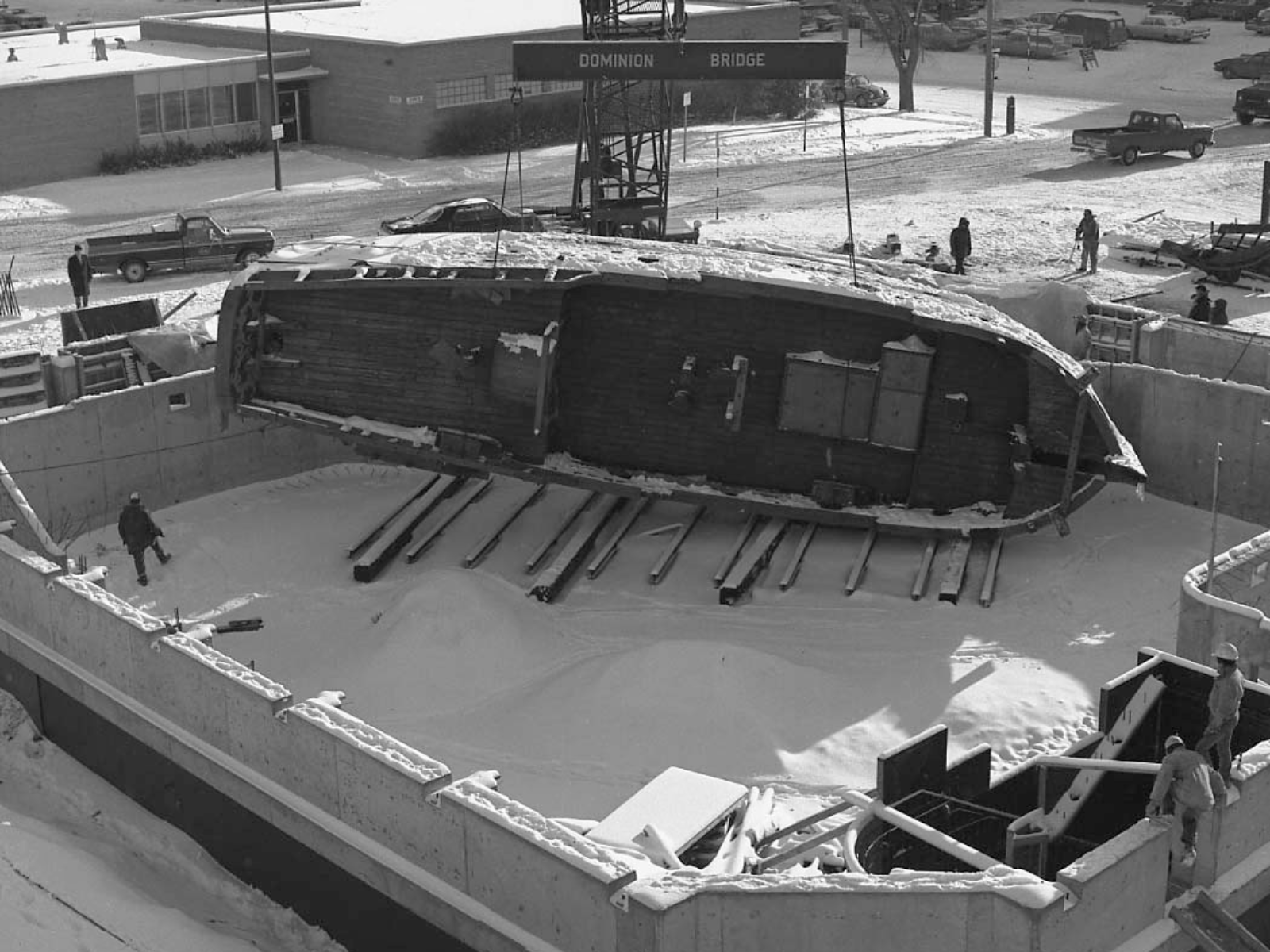 A black and white photograph of the Nonsuch on it's side in the border of what will become the Nonsuch Gallery.